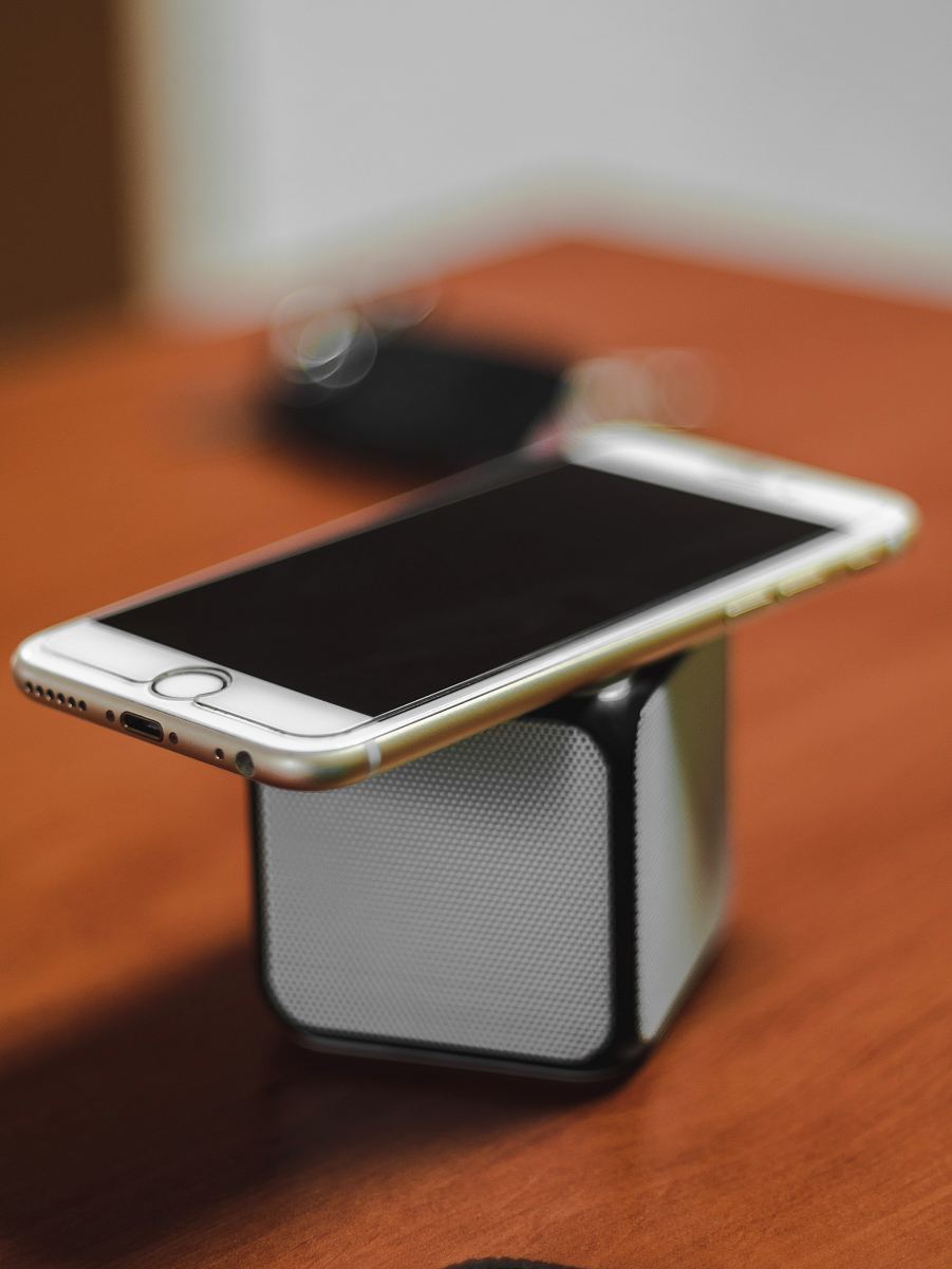 gold iPhone 6 on top of Bluetooth portable speaker